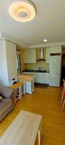 a kitchen with a couch and a table in a room at EnFOZ Terraza XXL Pet Friendly in Foz