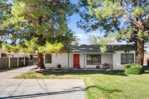 a house with a red door and two trees at Charming 2-BR Farmhouse Backyard Views in Mesa