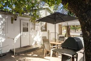a patio with a table and an umbrella at Charming 2-BR Farmhouse Backyard Views in Mesa