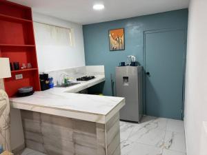a kitchen with a refrigerator and a counter top at Arubaapartamentos in Oranjestad