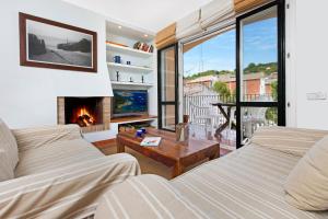 a living room with two couches and a fireplace at 1Sarri - Llafranc in Llafranc
