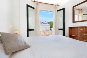a bedroom with a bed and a mirror and a window at 1Sarri - Llafranc in Llafranc