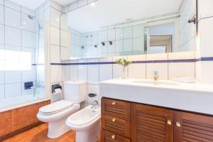a bathroom with a toilet and a sink and a mirror at 1Sarri - Llafranc in Llafranc +25 photos
