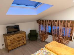a bedroom with a bed and a television and a chair at Casa Lalli in Longarone