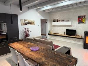 a kitchen and living room with a wooden table at Casa Lalli in Longarone
