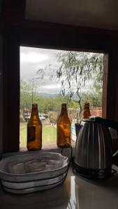 three bottles sitting on a counter with a window at Hospedaje Lourdes in Villa Yacanto