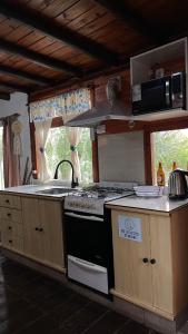 a kitchen with a stove and a counter top at Hospedaje Lourdes in Villa Yacanto