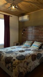 a bedroom with a bed with a quilt on it at Hospedaje Lourdes in Villa Yacanto +12 photos