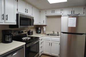 a kitchen with white cabinets and a stainless steel refrigerator at River Place Condos #401 2BD in Pigeon Forge