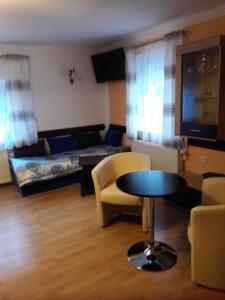 a living room with a couch and a table and chairs at Penzion Oáza Hřensko in Hřensko