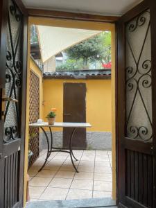 an open door with a table on a patio at Ninfea Como Lake - La casa del viandante in Bellano