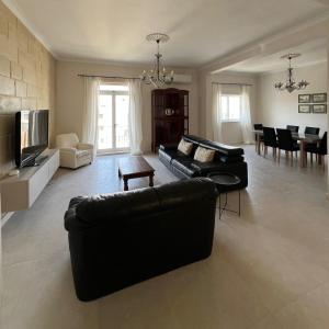 a living room with a couch and a dining room at Spacious & Central 3-Bedroom Apartment Close to the Sea in Taʼ Xbiex