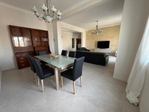a dining room with a glass table and black chairs at Spacious & Central 3-Bedroom Apartment Close to the Sea in Taʼ Xbiex