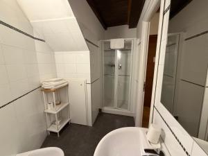 a white bathroom with a sink and a shower at La Dolce Vita in Riomaggiore