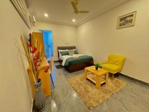 a bedroom with a bed and a yellow chair at Mayama Residences in Accra