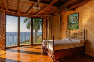 a bedroom with a bed with a view of the ocean at Montezuma Heights in Montezuma