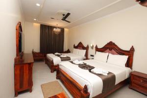 a hotel room with two beds and a flat screen tv at Hotel Shringar Mahal Vrindavan in Chhatikara +104 photos