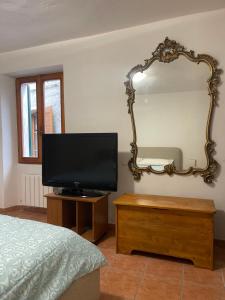 a bedroom with a flat screen tv and a mirror at Ninfea Como Lake - La casa del viandante in Bellano