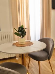 a white table with a potted plant on top of it at Onny's Palace in Bari