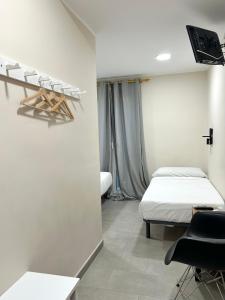 a bedroom with a bed and a desk and a chair at Be Ramblas Guest House in Barcelona