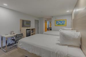 a bedroom with two beds and a desk with a computer at Townhouse Fort Walton Beach Hurlburt Field in Mary Esther