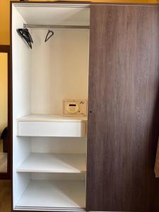 a closet with white shelves and a wooden door at Nirvana Yogashala Retreat in Mysore