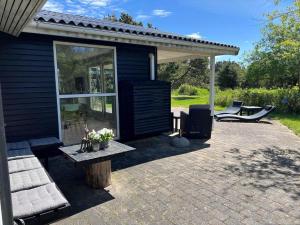 a patio of a house with a table and chairs at VE160-Vejers-Strand-Engesovej-69 in Vejers Strand