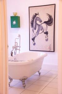 a bathroom with a painting of a horse on the wall at Rooms At Greystoke in Criccieth