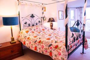 a bedroom with a bed with a floral bedspread at Rooms At Greystoke in Criccieth +86 photos