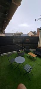 a group of chairs and a table on the grass at L'Escale Chaunoise in Chauny