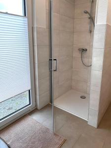 a bathroom with a shower with a glass door at Gemütlicher Bungalow bei Aalen,Abtsgmünd in Abtsgmünd +26 photos