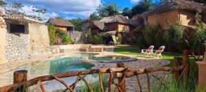 a resort with a swimming pool in a yard at Cabañas Aldea Yalcón in Valladolid