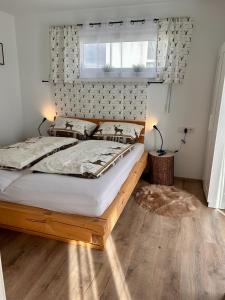 a bedroom with a bed with a wooden frame and a window at Gemütlicher Bungalow bei Aalen,Abtsgmünd in Abtsgmünd
