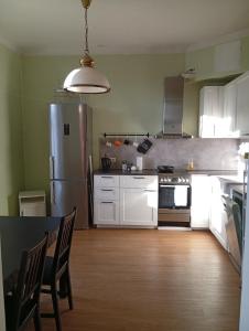 a kitchen with a refrigerator and a table with chairs at Lendle Apartment Märjamaa in Märjamaa