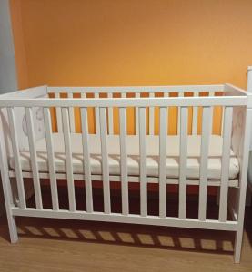 a white crib sitting in a room at Lendle Apartment Märjamaa in Märjamaa