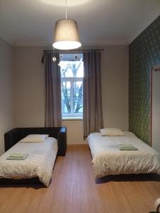 a bedroom with two beds and a window at Lendle Apartment Märjamaa in Märjamaa