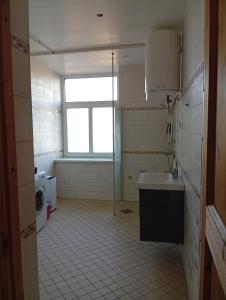 a bathroom with a sink and a toilet and a window at Lendle Apartment Märjamaa in Märjamaa