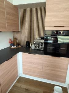a kitchen with wooden cabinets and a stove top oven at Rolig base under smukfest in Skanderborg