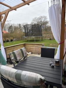 a deck with a table and a basketball hoop at Rolig base under smukfest in Skanderborg