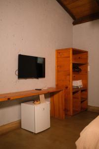 a room with a tv on a wall with a cabinet at Pousada Aldeia da Serra in Palmas