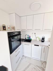a kitchen with white cabinets and a black oven at Villa Bavaria in Ritopek