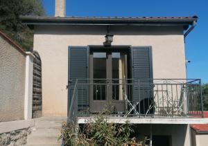 a balcony with green shutters on a building at Gîte d'étape Chez Isa in Vers