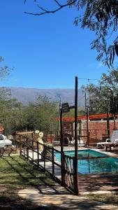 a swimming pool with a wooden fence around it at Hospedaje Lourdes in Villa Yacanto