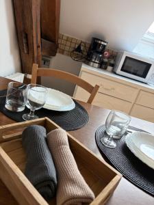 a wooden table with plates and glasses on top of it at Studio 16 proche du PAL in Dompierre-sur-Besbre