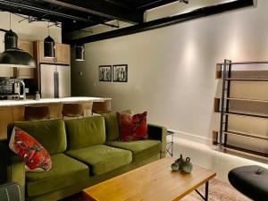 a living room with a green couch and a table at Classic Pied a Terre in Benton Harbor