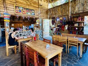 two people sitting at tables in a restaurant at Eco-Hotel Mayachik in San Juan La Laguna