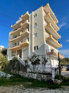 a tall white building with stairs in front of it at Bleta Residence in Sarandë