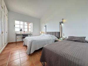 a bedroom with two beds and a desk and a window at Casa Alegria in Puerto Rico de Gran Canaria +71 photos