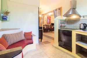 a kitchen and a living room with a couch and a stove at Villa Markella in Chrysi Ammoudia
