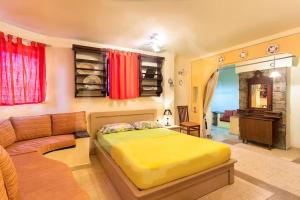 a bedroom with a yellow bed and a couch at Villa Markella in Chrysi Ammoudia